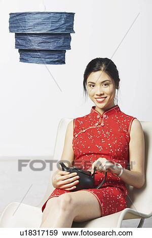Stock Photo - Close-up of a young woman holding a tea kettle. Fotosearch