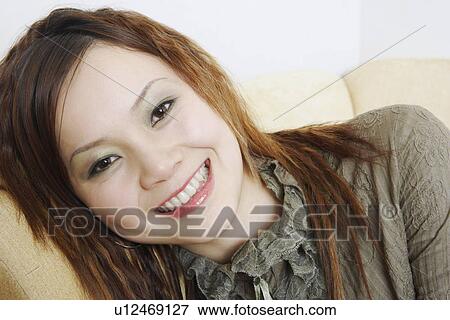 Close-up of a young woman smiling View Large Photo Image Stock Photo - Close-up of a young woman smiling. Fotosearch