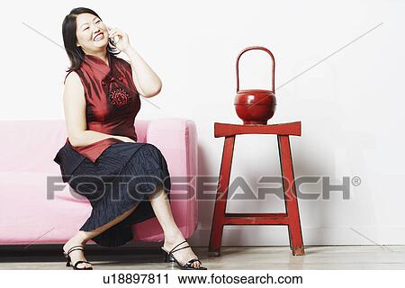 Stock Image - Mid adult woman talking on a mobile phone. Fotosearch