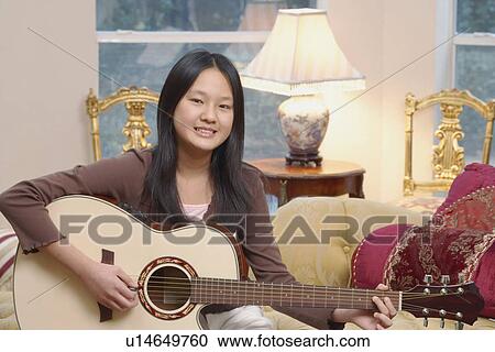 Portrait of a girl playing the guitar View Large Photo Image Stock Image - Portrait of a girl playing the guitar. Fotosearch