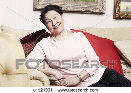 Portrait of a senior woman sitting on a couch View Large Photo Image Stock Image - Portrait of a senior woman sitting on a couch. Fotosearch