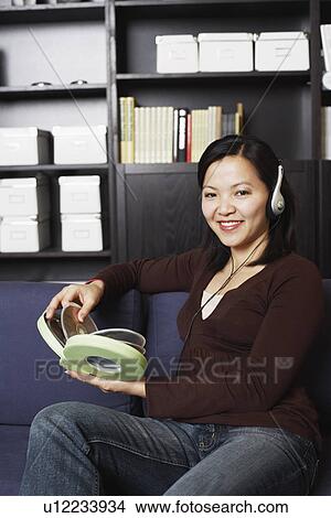 Picture - Portrait of a young woman listening to music on headphones. Fotosearch