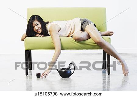 Stock Photo - Portrait of a young woman lying down. Fotosearch