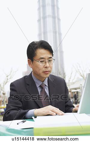Stock Photo - Close-up of a businessman using a laptop. Fotosearch