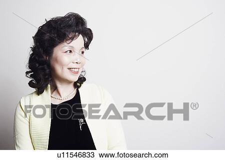 Stock Image - Close-up of a businesswoman looking sideways smiling. Fotosearch