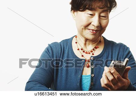 Close-up of a mature woman looking at a mobile phone View Large Photo Image Stock Image - Close-up of a mature woman looking at a mobile phone. Fotosearch