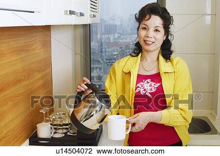 Close-up of a mature woman pouring coffee into a cup View Large Photo Image Stock Image - Close-up of a mature woman pouring coffee into a cup. Fotosearch