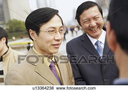 Stock Photo - Close-up of two businessmen smiling. Fotosearch