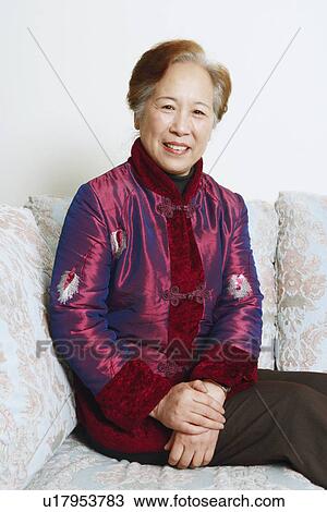 Portrait of a mature woman sitting on a couch View Large Photo Image Stock Image - Portrait of a mature woman sitting on a couch. Fotosearch