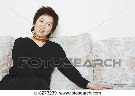 Portrait of a mature woman sitting on a couch View Large Photo Image Stock Photo - Portrait of a mature woman sitting on a couch. Fotosearch