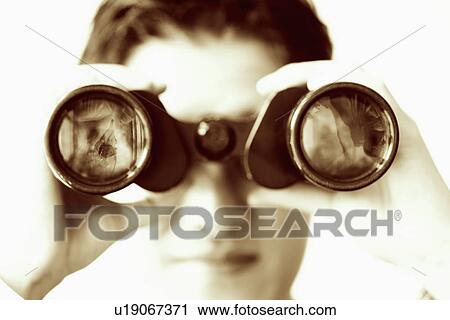 Stock Image - Close-up of a businessman looking through a pair of binoculars. Fotosearch