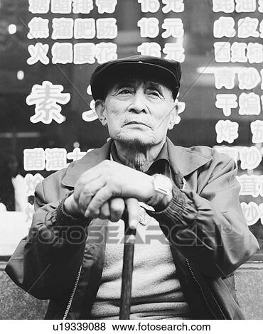 Low angle view of a senior man sitting and holding a cane View Large Photo Image Stock Photo - Low angle view of a senior man sitting and holding a cane. Fotosearch
