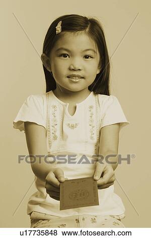 Stock Photo - Portrait of a girl holding an envelope and smiling. Fotosearch