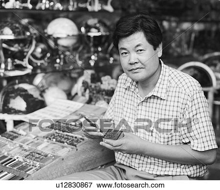 Portrait of a mid adult man sitting in a store View Large Photo Image Stock Photo - Portrait of a mid adult man sitting in a store. Fotosearch