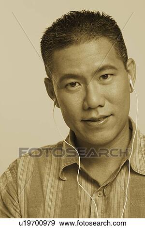 Portrait of a mid adult man wearing headphones and listening to music View Large Photo Image Stock Photo - Portrait of a mid adult man wearing headphones and listening to music. Fotosearch