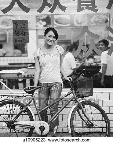 Portrait of a teenage girl standing with her bicycle in front of a restaurant View Large Photo Image Stock Image - Portrait of a teenage girl standing with her bicycle in front of a restaurant. Fotosearch