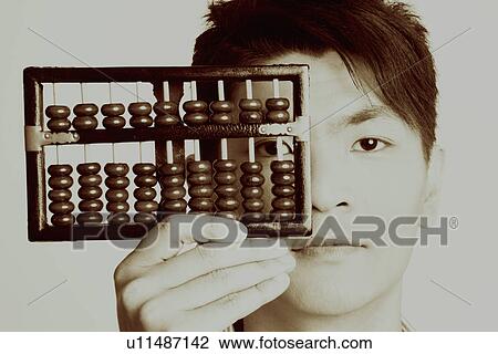 Portrait of a young man holding an abacus View Large Photo Image Stock Image - Portrait of a young man holding an abacus. Fotosearch