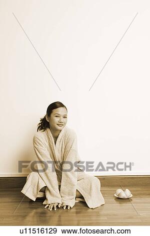 Stock Photo - Portrait of a young woman sitting on the floor with a plate of soap. Fotosearch