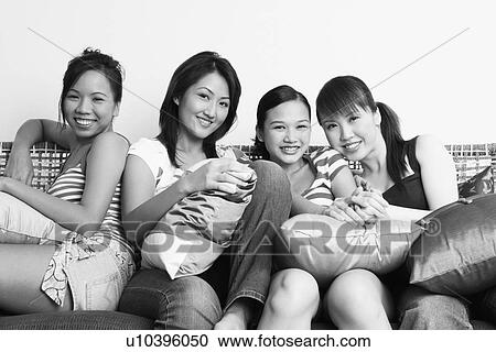 Portrait of four young women sitting on a couch and smiling View Large Photo Image Stock Image - Portrait of four young women sitting on a couch and smiling. Fotosearch