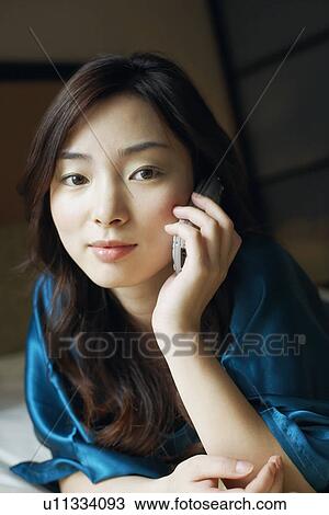 Close-up of a young woman talking on a mobile phone View Large Photo Image Stock Image - Close-up of a young woman talking on a mobile phone. Fotosearch