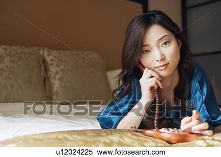 Stock Photography - Close-up of a young woman talking on the telephone. Fotosearch