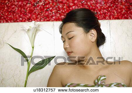 High angle view of a young woman lying on the floor near a hot tub filled with rose petals View Large Photo Image Stock Photo - High angle view of a young woman lying on the floor near a hot tub filled with rose petals. Fotosearch