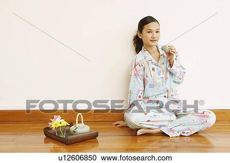 Portrait of a young woman holding a tea cup View Large Photo Image Stock Image - Portrait of a young woman holding a tea cup. Fotosearch