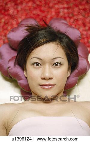 Portrait of a young woman lying on floor near a hot tub filled with rose petals View Large Photo Image Stock Image - Portrait of a young woman lying on floor near a hot tub filled with rose petals. Fotosearch