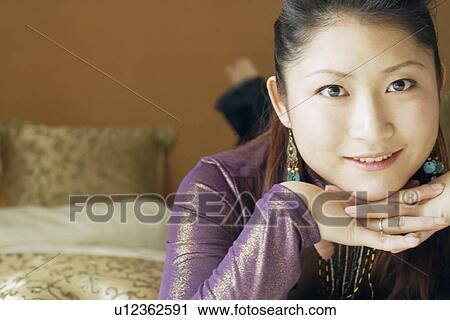 Stock Image - Portrait of a young woman with her hand on her chin. Fotosearch