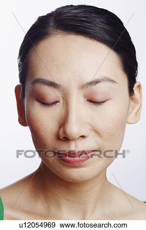Stock Photo - Close-up of a mid adult woman with her eyes closed. Fotosearch