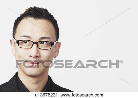 Stock Image - Close-up of a young man looking up. Fotosearch