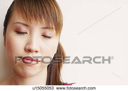 Stock Image - Close-up of a young woman thinking. Fotosearch