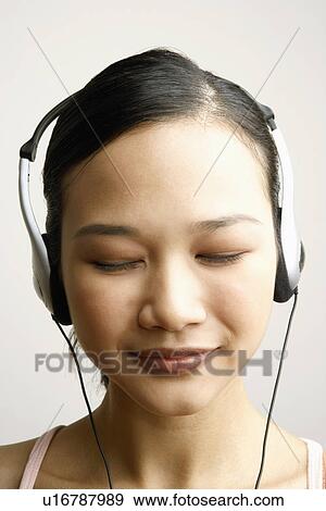 Stock Photo - Close-up of a young woman wearing headphones. Fotosearch