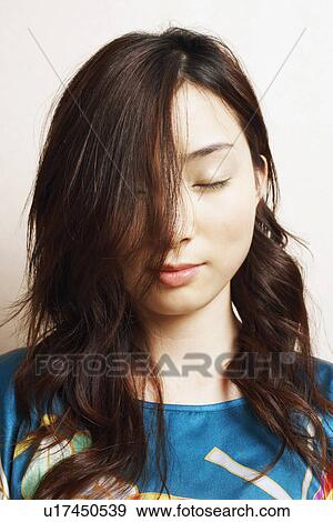 Stock Photo - Close-up of a young woman with her eyes closed. Fotosearch