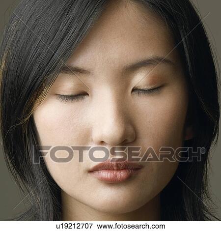 Stock Photo - Close-up of a young woman with her eyes closed. Fotosearch