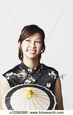 Close-up of a young woman holding a parasol View Large Photo Image Stock Image - Close-up of a young woman holding a parasol. Fotosearch