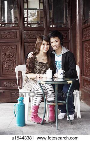 Stock Image - Portrait of a teenage boy with a young woman sitting in a restaurant smiling. Fotosearch