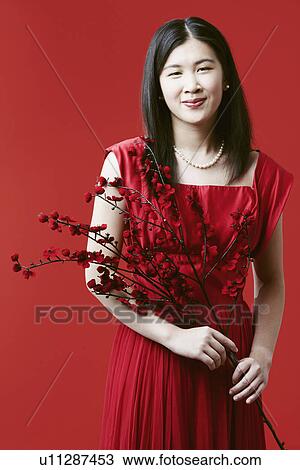 Stock Image - Portrait of a young woman holding flowers. Fotosearch
