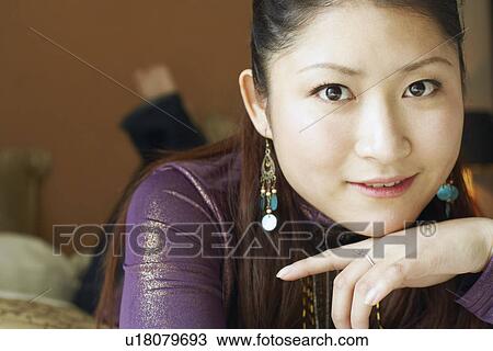 Portrait of a young woman lying on her front smiling View Large Photo Image Stock Image - Portrait of a young woman lying on her front smiling. Fotosearch