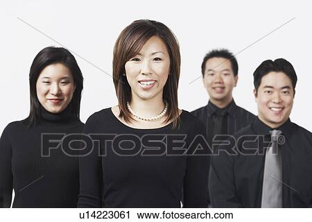 Stock Image - Portrait of two businessmen and two businesswomen smiling. Fotosearch