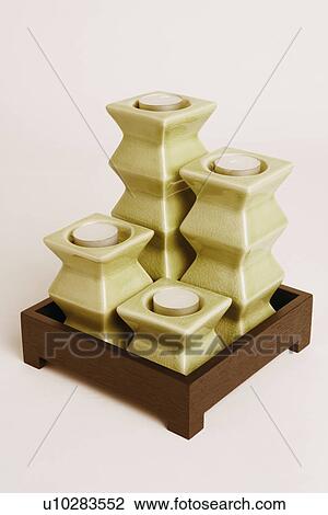 Stock Image - Close-up of four candles in a wooden box. Fotosearch