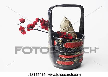 Picture - Close-up of rice wrapped in banana leaves in a basket. Fotosearch