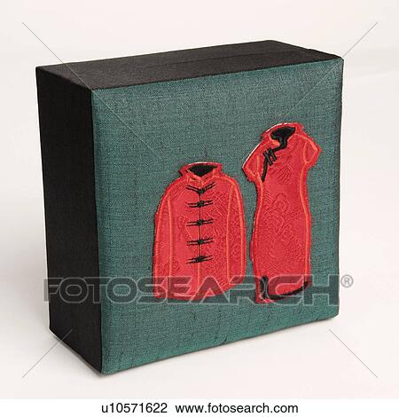 Stock Image - Close-up of traditional Chinese outfits embroidered on a box. Fotosearch