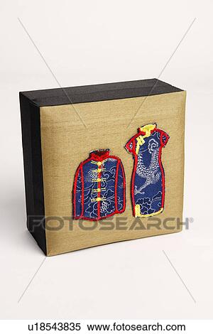 Stock Photography - Close-up of traditional Chinese outfits embroidered on a box. Fotosearch