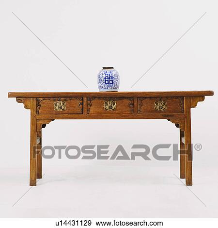 Stock Photo - Decorative urn on a wooden desk. Fotosearch