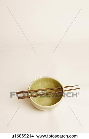 Picture - High angle view of a bowl and two chopsticks. Fotosearch
