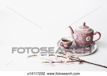 Stock Image - High angle view of a cup of black tea and a teapot on a tray. Fotosearch