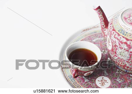 Stock Image - High angle view of a cup of black tea and a teapot on a tray. Fotosearch