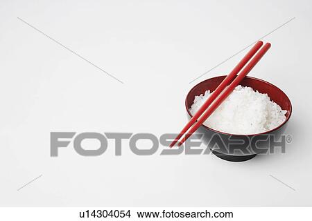 Picture - High angle view of a pair of chopsticks on a bowl of rice. Fotosearch