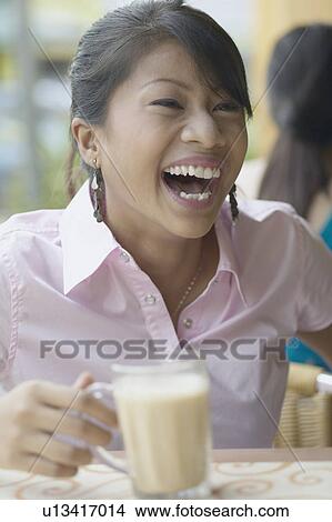 Close-up of a young woman holding a milkshake View Large Photo Image Picture - Close-up of a young woman holding a milkshake. Fotosearch
